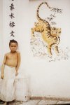 Bac Ky, 1916 - Little boy standing by tiger relief (in front of Vinh Thuy temple gate) Photo b...jpg